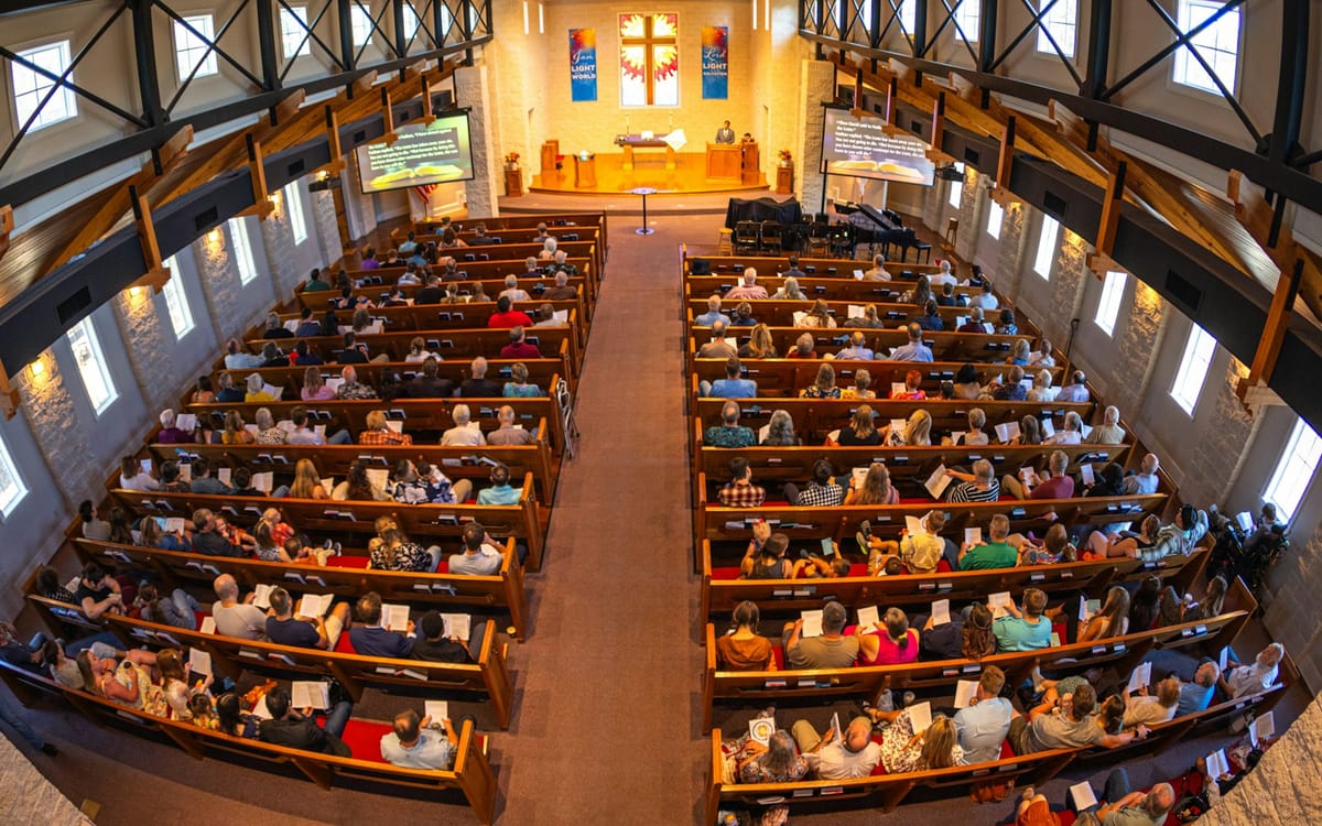 A full sanctuary seen from above, rows of pews filled for worship
